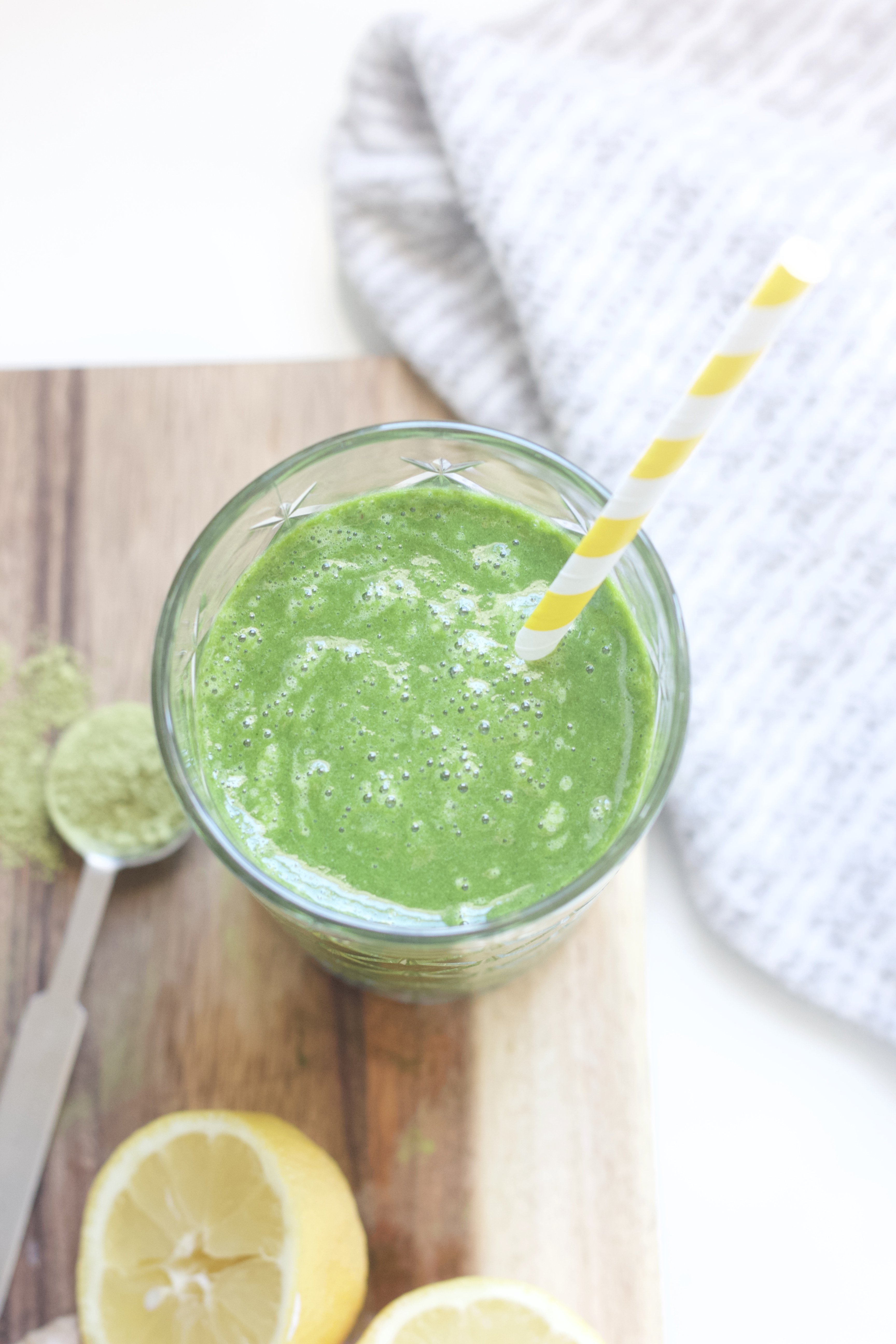 A flatlay of a green smoothie on a cutting board