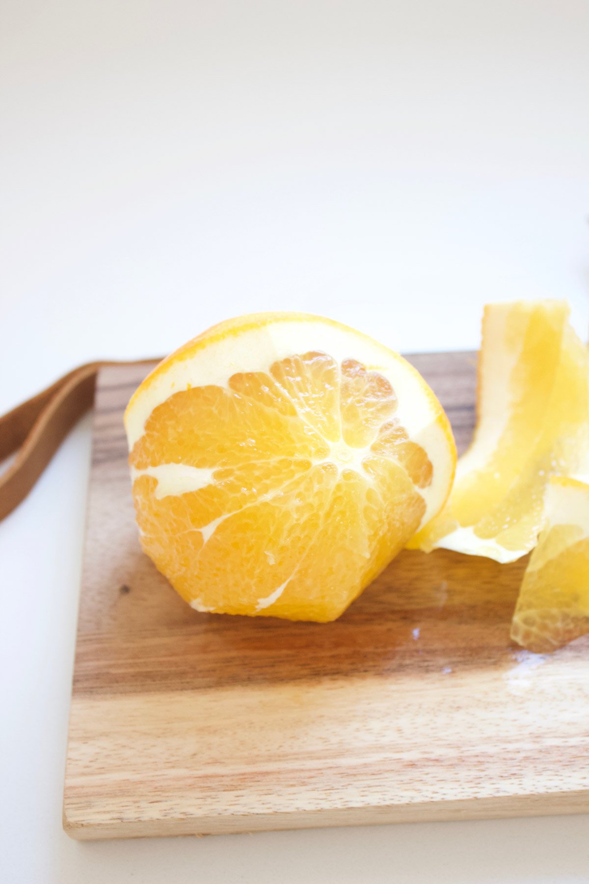 Peeled navel orange on a cutting board.