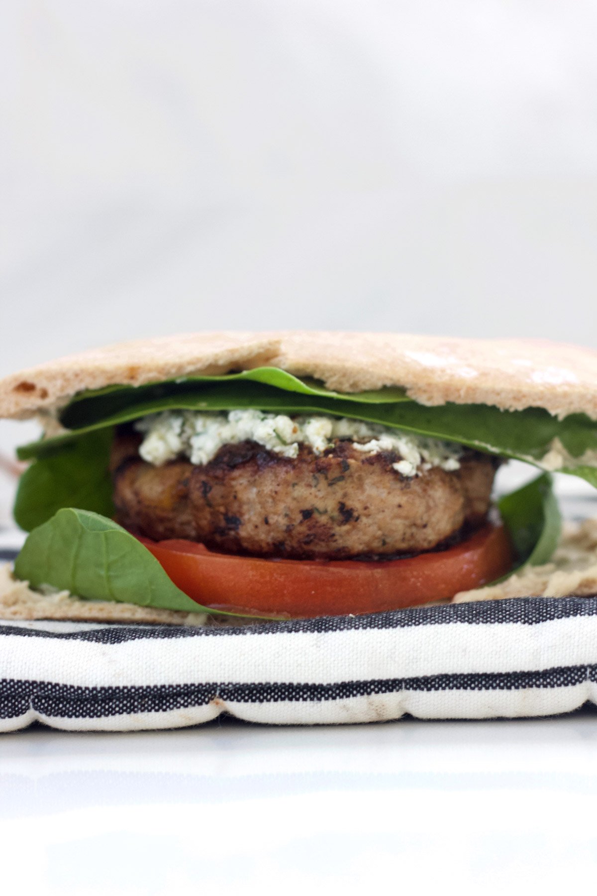 Turkey burger with herbed feta, spinach, tomato and hummus