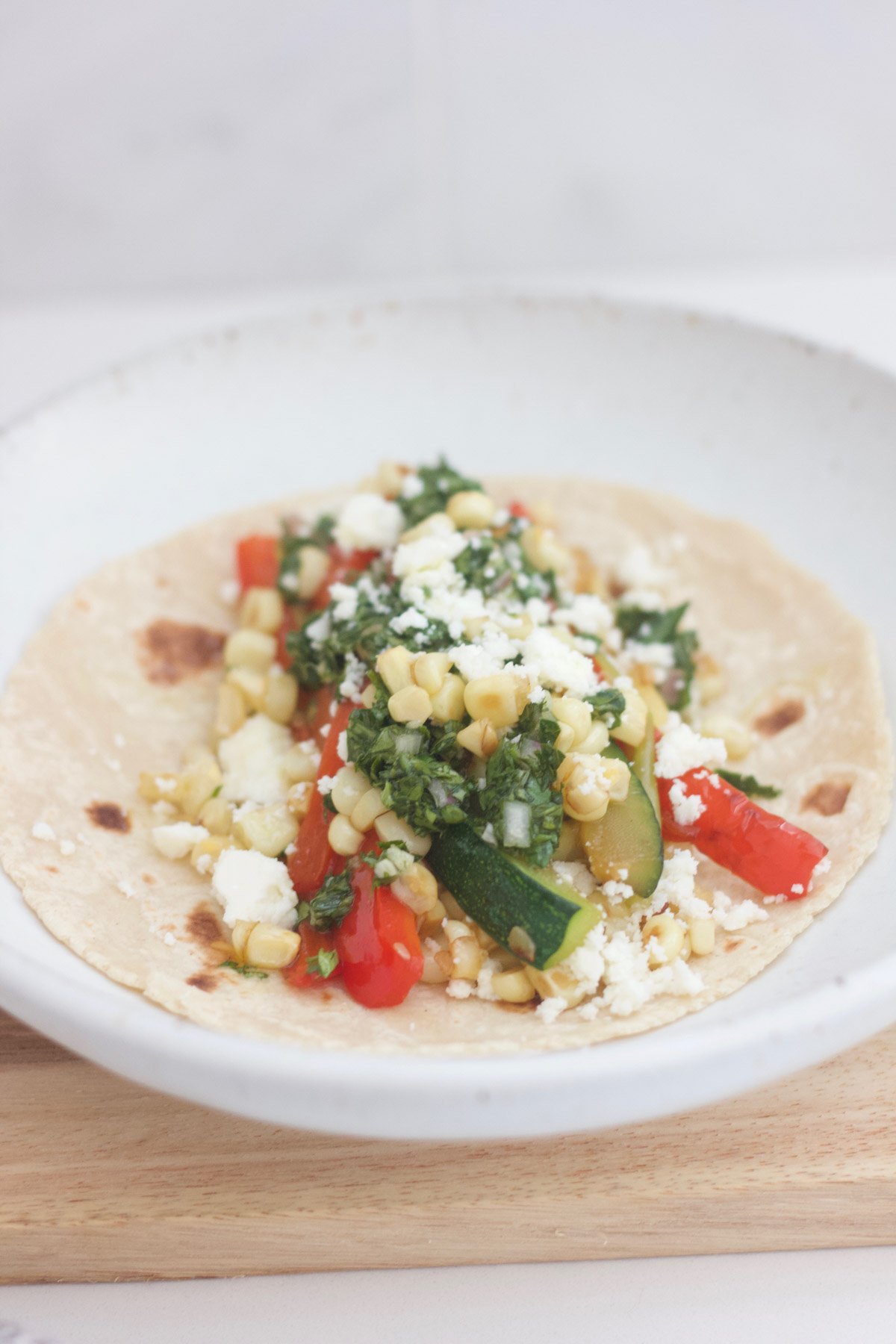 Taco with red pepper, zucchini, corn and cheese.