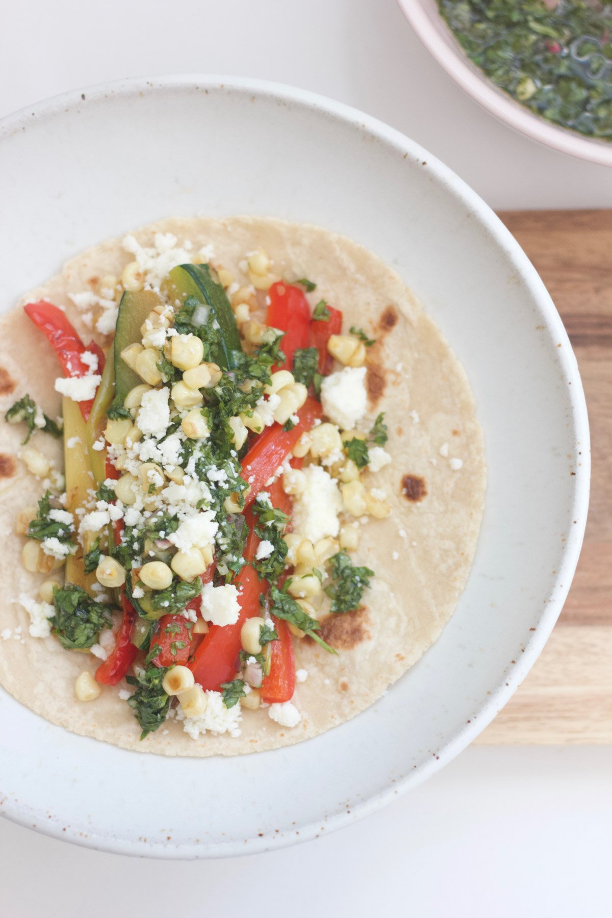 Veggie tacos with red pepper, zucchini, corn and cheese.