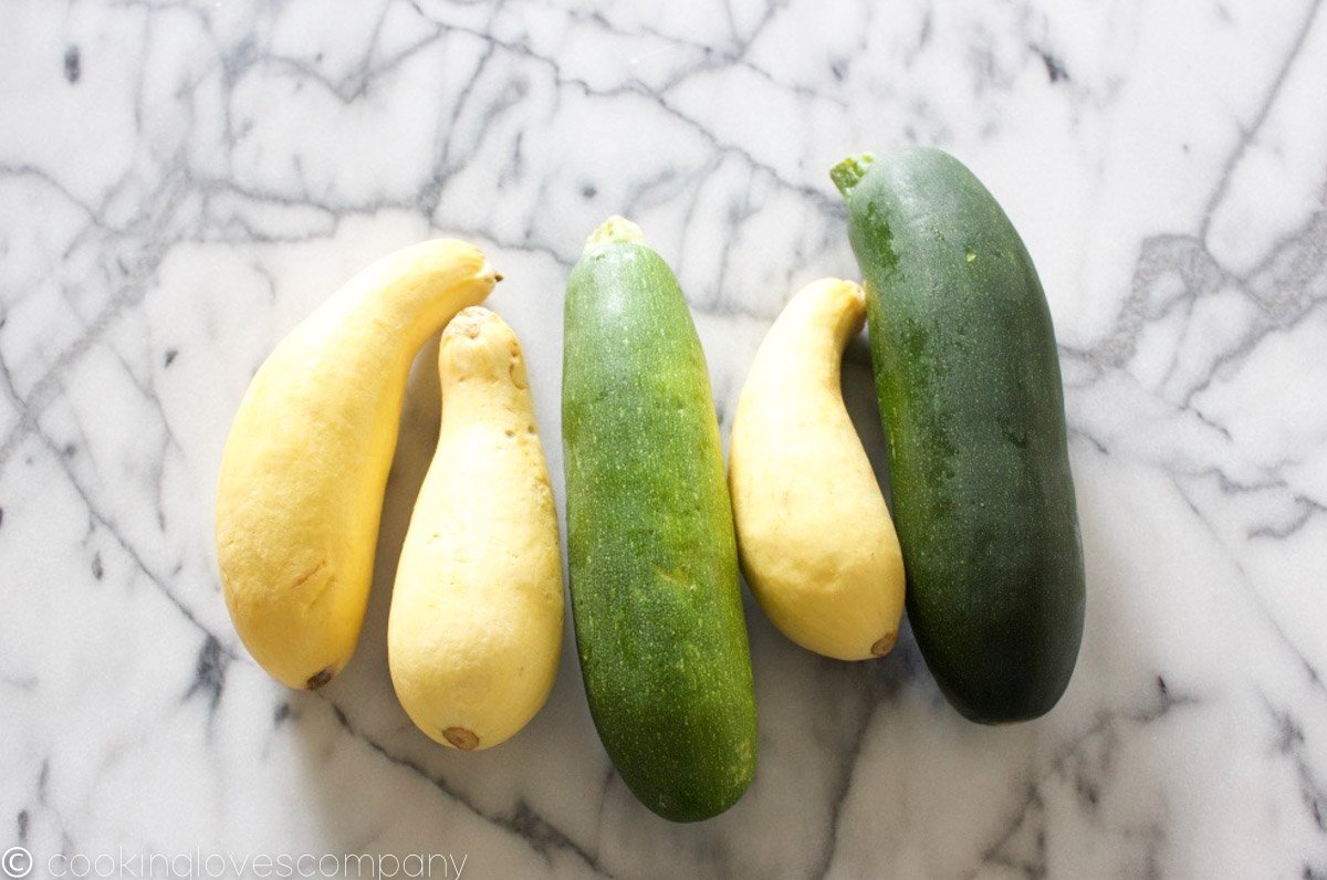 Yellow and green summer squash on a marble counter