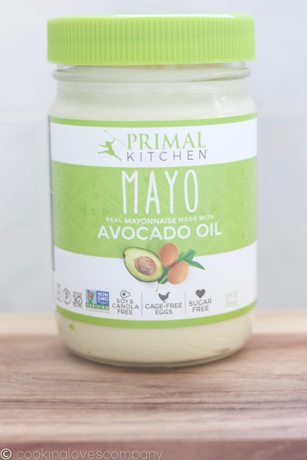 A jar of Primal Kitchen Mayo with Avocado Oil on a wood cutting board.