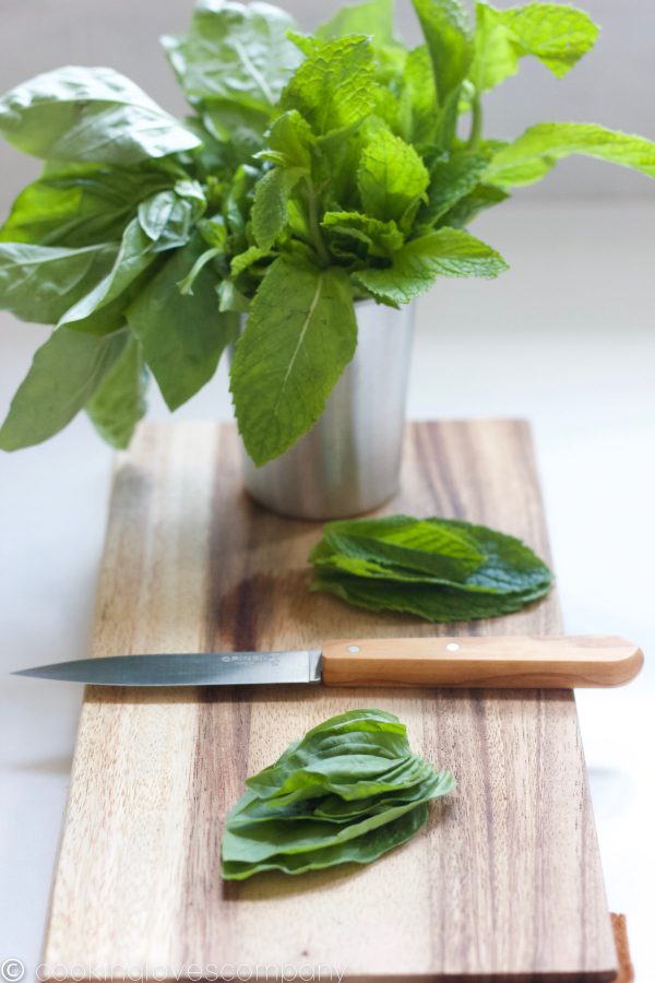 Basil and Mint in a small stainless steel cup on a cutting board