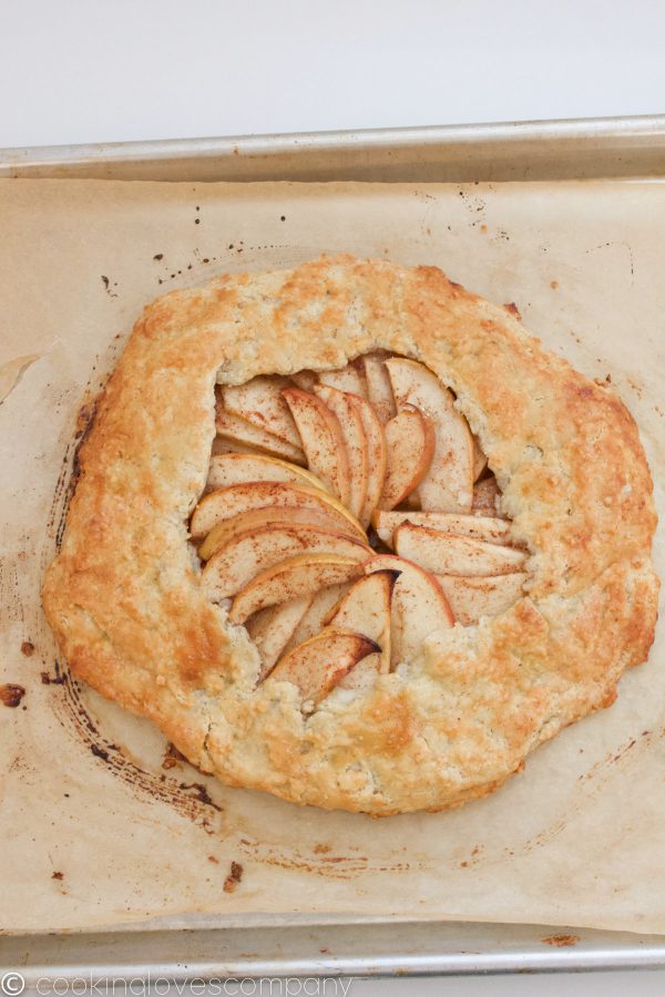 Cooked apple galette on a parchment lined baking sheet