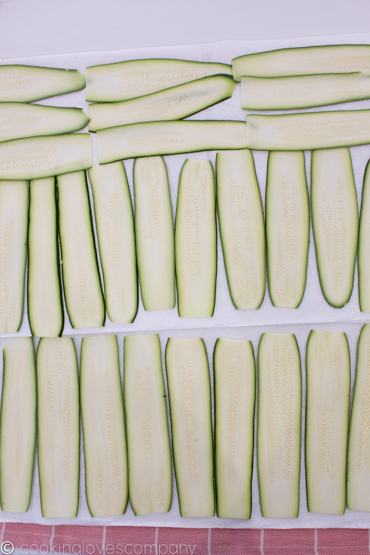 Zucchini slices in 3 rows on a paper towel